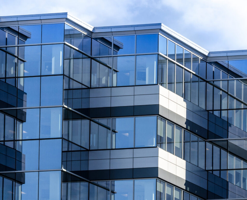 Close up of a modern building with sharp-angled windows.