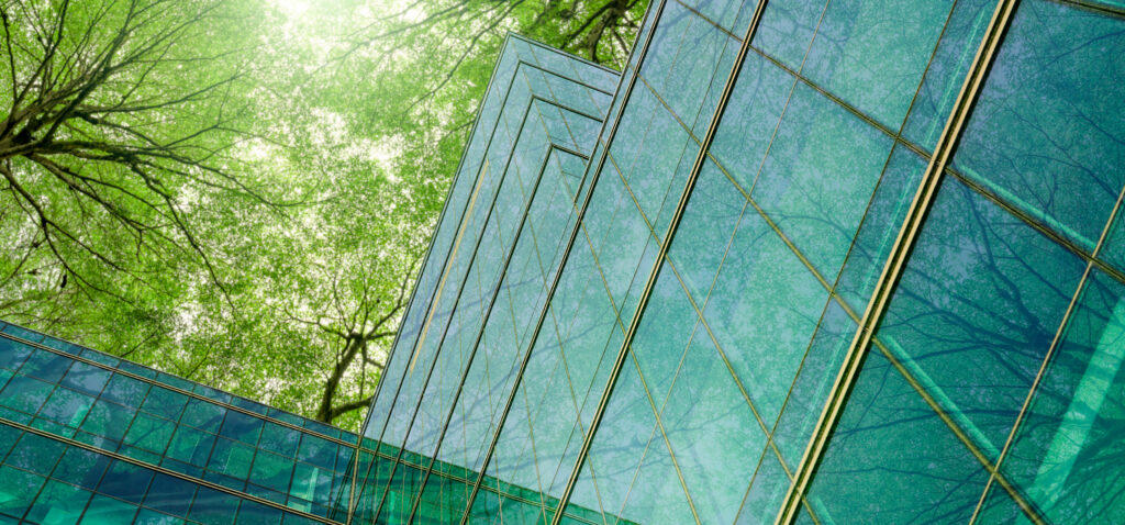 Sustainable glass office building with trees in the background.
